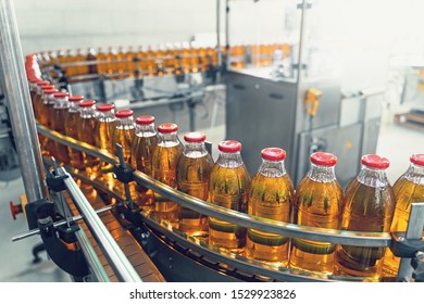 Conveyor belt, juice in glass bottles on beverage plant or factory interior, industrial manufacturing production line, toned - Shutterstock ID 1529923826