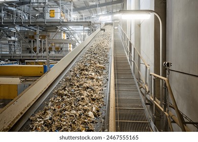 Conveyor belt transporting refuse-derived fuel (RDF) in an industrial recycling facility, showcasing the waste sorting and processing system used for renewable energy production. - Powered by Shutterstock