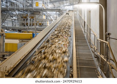 Conveyor belt transporting refuse-derived fuel (RDF) with motion blur effect in an industrial recycling facility, highlighting the dynamic waste sorting and processing system for renewable energy. - Powered by Shutterstock