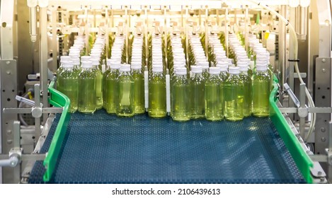 Conveyor with bottles for juice or water in factory interior of beverage plant. - Shutterstock ID 2106439613