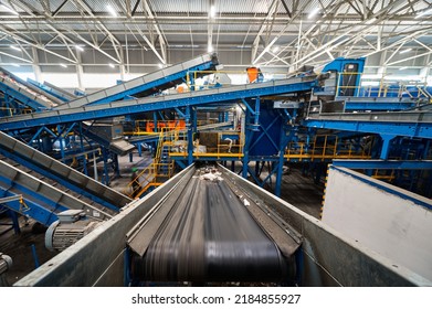 Conveyor carries trash pieces in recycling plant workshop - Shutterstock ID 2184855927