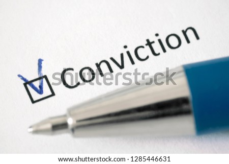 Conviction - checkbox with a tick on white paper with pen. Checklist concept.