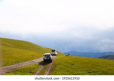 a convoy of cars is moving along a dirt road. travel by car in the mountains. rough road in the steppe. jeeps make their way through the desert