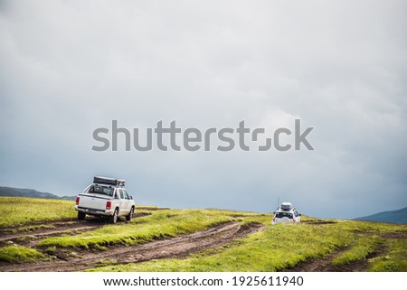 a convoy of cars is moving along a dirt road. travel by car in the mountains. rough road in the steppe. jeeps make their way through the desert