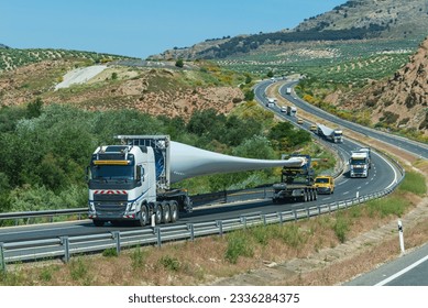 Convoy of trucks transporting wind turbine blades.