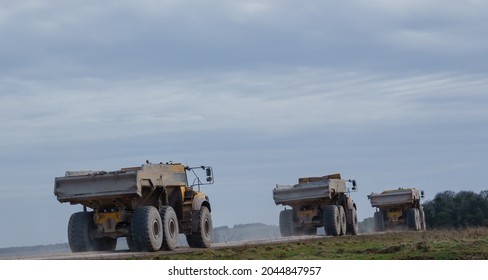 A Convoy Of Yellow Volvo A40E Articulated Dump Truck Earth Movers With 25 Tonne Payload Driving Across Salisbury Plain, Wiltshire UK