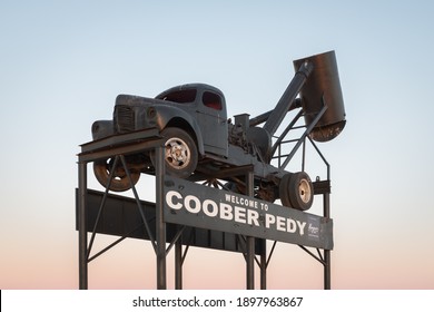 Coober Pedy, Australia - July 06, 2020: The Blower, Opal mining shaft clearing truck as an iconic tourist landmark. Welcome to Coober Pedy town entry road sign.