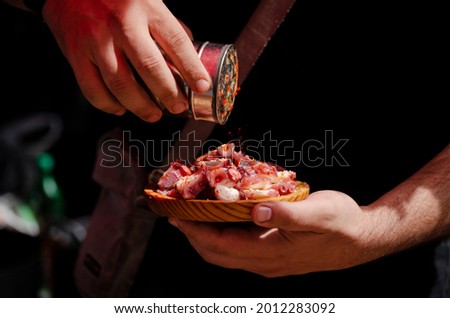 Cook adding paprika to a portion of Octopus a Feira, typical Galician recipe for cooking octopus.