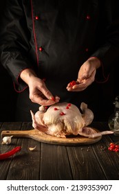 The Cook Adds Red Viburnum To The Broiler Chicken Before Roasting. Cooking National Dishes In The Kitchen Of The Restaurant.