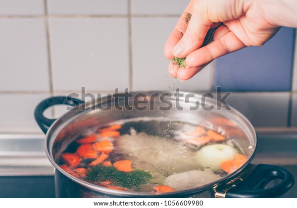 The cook
adds salt, pepper and spices to the
soup