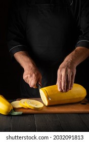 The Cook Cuts Ripe Yellow Marrow With A Knife. Fried Zucchini Is A Great Diet For Breakfast Or Lunch. Work Environment On The Kitchen Table Of The Restaurant.