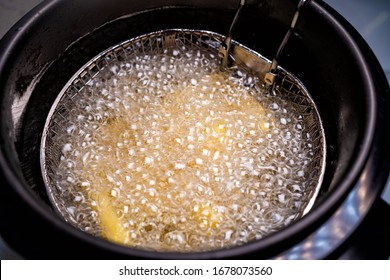 Cook French Fries. Oil Boiling In A Deep Fryer At Home. Top View. Close Up.