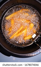 Cook French Fries. Oil Boiling In A Deep Fryer At Home. Top View. Close Up.