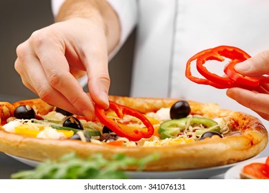 Cook making delicious pizza at the restaurant, close-up - Powered by Shutterstock