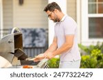 Cook man preparing barbecue grill outdoor. Man cooking tasty food on barbecue grill at backyard. Chef preparing food on barbecue. Millennial man grilling meat on grill. Bbq party. Meal grilling.