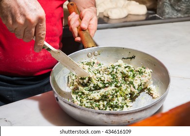 A cook mixing rice, spinach, jam and parmesan cheese to make the typical sicilian arancini - Powered by Shutterstock