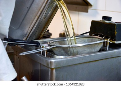 Cook Pouring (refilling) Liters Of Refined Oil For Deep Fat Frying In Electric Modern Heating Machine. Unhealthy Fat Not Organic Vegetable Refined Sunflower Light Greasy Oil, Palmolein, Hydrogenated.