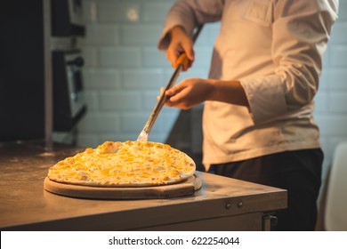 Cook Preparing Pizza In Kitchen