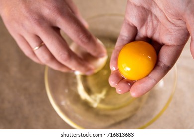 the cook separates the yolk in the egg - Shutterstock ID 716813683