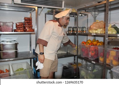 Cook Shows How Food Is Stored On The Shelves Of The Refrigerator In The Restaurant’s Kitchen. Moscow 2018.