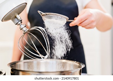 A Cook Sifts The Powdered Sugar Through A Sieve To Prepare Dough In A Mixer Bowl. Cooking Courses. Bread And Dessert Recipes. Family Business. Online Lessons For Cooks.