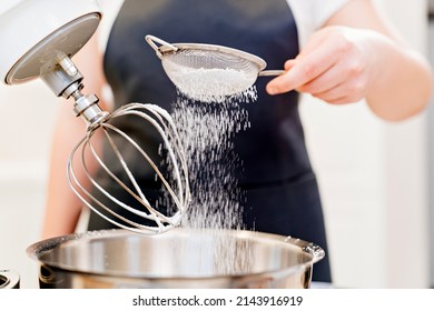 A Cook Sifts The Powdered Sugar Through A Sieve To Prepare Dough In A Mixer Bowl. Cooking Courses. Bread And Dessert Recipes. Family Business. Online Lessons For Cooks.