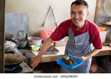the cook smiled as he turned on the stove to fry the side dishes for the customers at the food stall