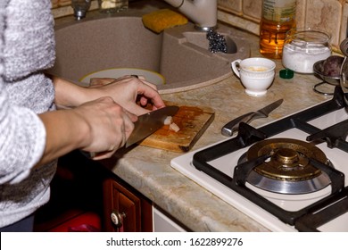 The Cook Stands Near The Desktop And Is Getting Ready For Work. The Lunch Is Getting Ready In Kitchen