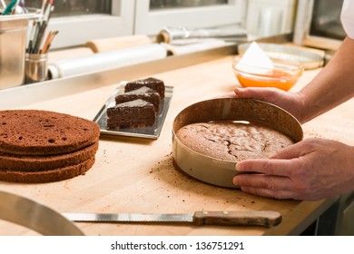 Cook taking out layer cake from cake form