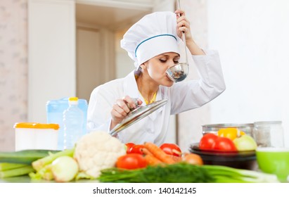  Cook In White Uniform Tests Soup From Ladle At Commercial Kitchen   