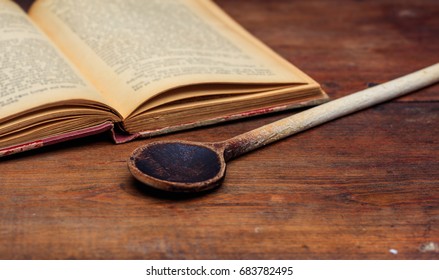 Cookbook Concept. Wooden Ladle And A Vintage Book 
