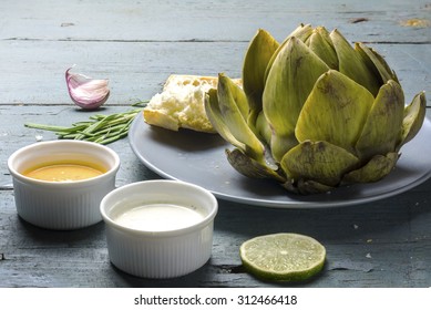 Cooked Artichoke With Dips And Bread On A Rustic Gray Blue Wooden Table 