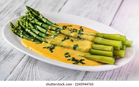 Cooked asparagus with Hollandaise sauce on the serving plate