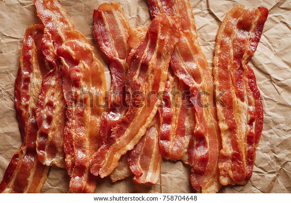 Cooked bacon rashers on\
parchment