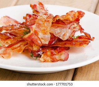 Cooked Bacon Rashers On A White Plate. Selective Focus