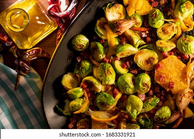 Cooked brussels sprouts (cabbages) with ham, garlic, oil and orange. Rustic and homemade looking recipe.