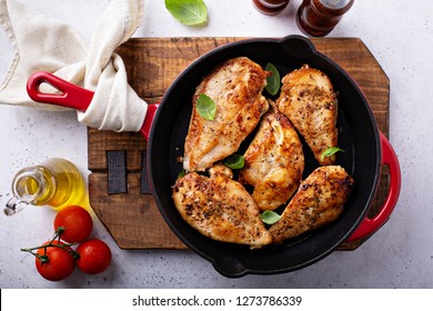 Cooked chicken breast seared in a cast iron skillet overhead