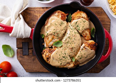 Cooked Chicken Breast Seared In A Cast Iron Skillet With Creamy Pan Sauce