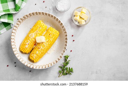 Cooked corn on the cob served with parmesan cheese , salt and butter. Light gray background. Top view - Powered by Shutterstock