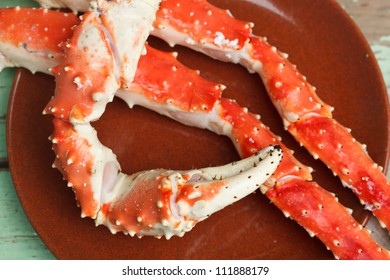 Cooked Crab Legs On A Plate Ready For Cracking To Extract The Meat, One With A Pincer