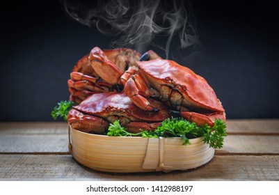 Cooked crab on steamer and dark background / Seafood boiled red stone crabs