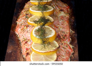 A Cooked Fillet Of Sockeye Salmon With Dill And Lemon On Cedar Plank