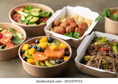 Cooked food in paper eco-friendly containers. Food delivery for home or office. Vegetable, fruit salads and noodles 