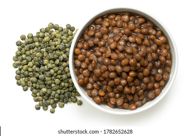 Cooked French Green Puy Lentils In White Ceramic Bowl Next To Dry Lentils Isolated On White. Top View.