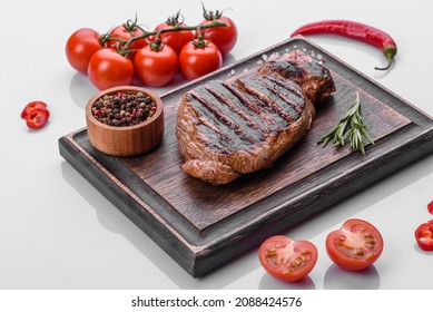 Cooked Grilled Chuck Eye Roll Steak On A Chopping Board. Dark Background