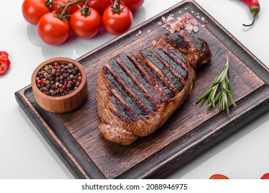 Cooked Grilled Chuck Eye Roll Steak On A Chopping Board. Dark Background