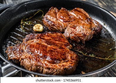 Cooked Grilled Marble Steak Chuck Roll In A Pan. Dark Background. Top View