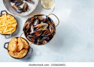 Cooked Mussels With Toasted Bread, French Fries, And White Wine, Overhead Flat Lay Shot On A Slate Background With A Place For Text