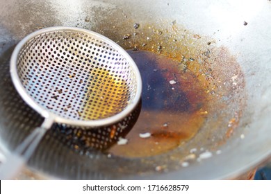 Cooked Oil In A Colander Ladle And In A Pan. The Oil Used For Frying Food Should Not Be Reused Because It Contains Carcinogens. Health Care Concept.