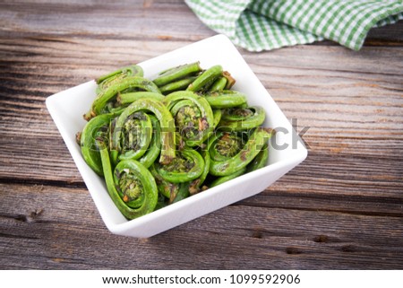 cooked ostrich fiddleheads ferns with garlic